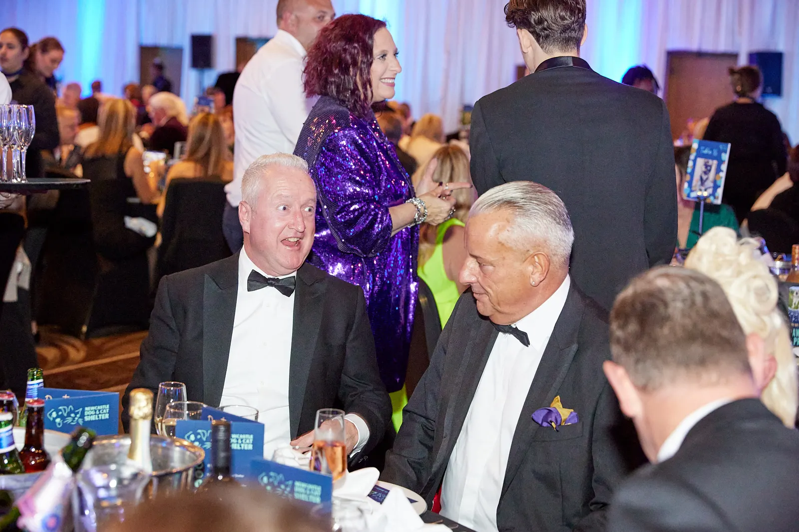 Guests in black tie laughing together at a charity gala dinner in Newcastle
