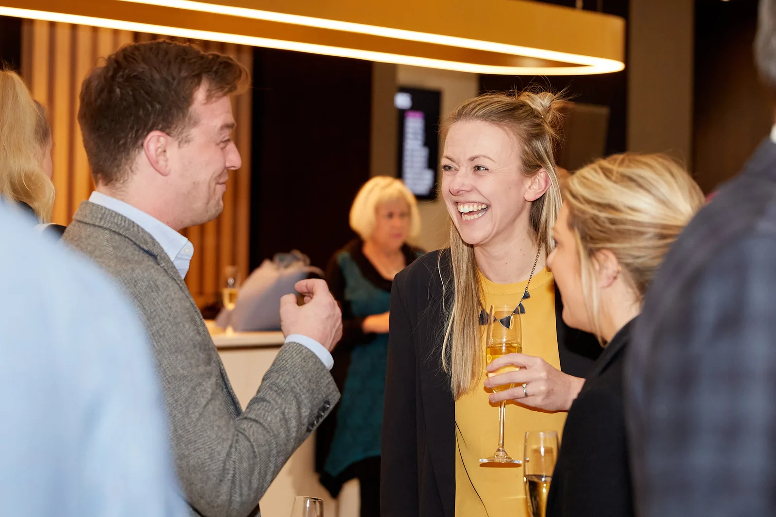 Two delegates laughing over champagne at a conference evening reception