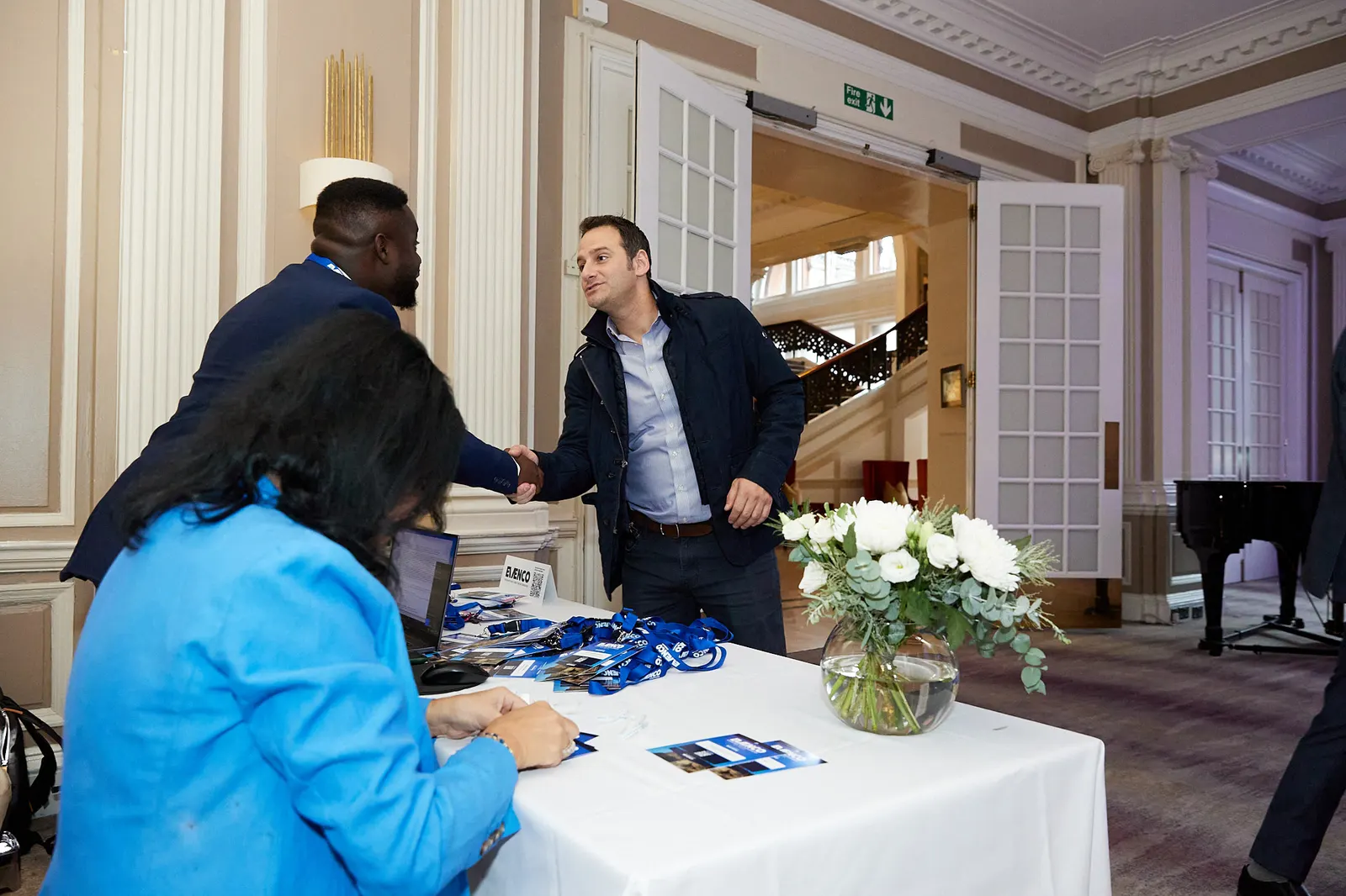 Delegate welcomed with a handshake at the registration desk of an Edinburgh fund forum