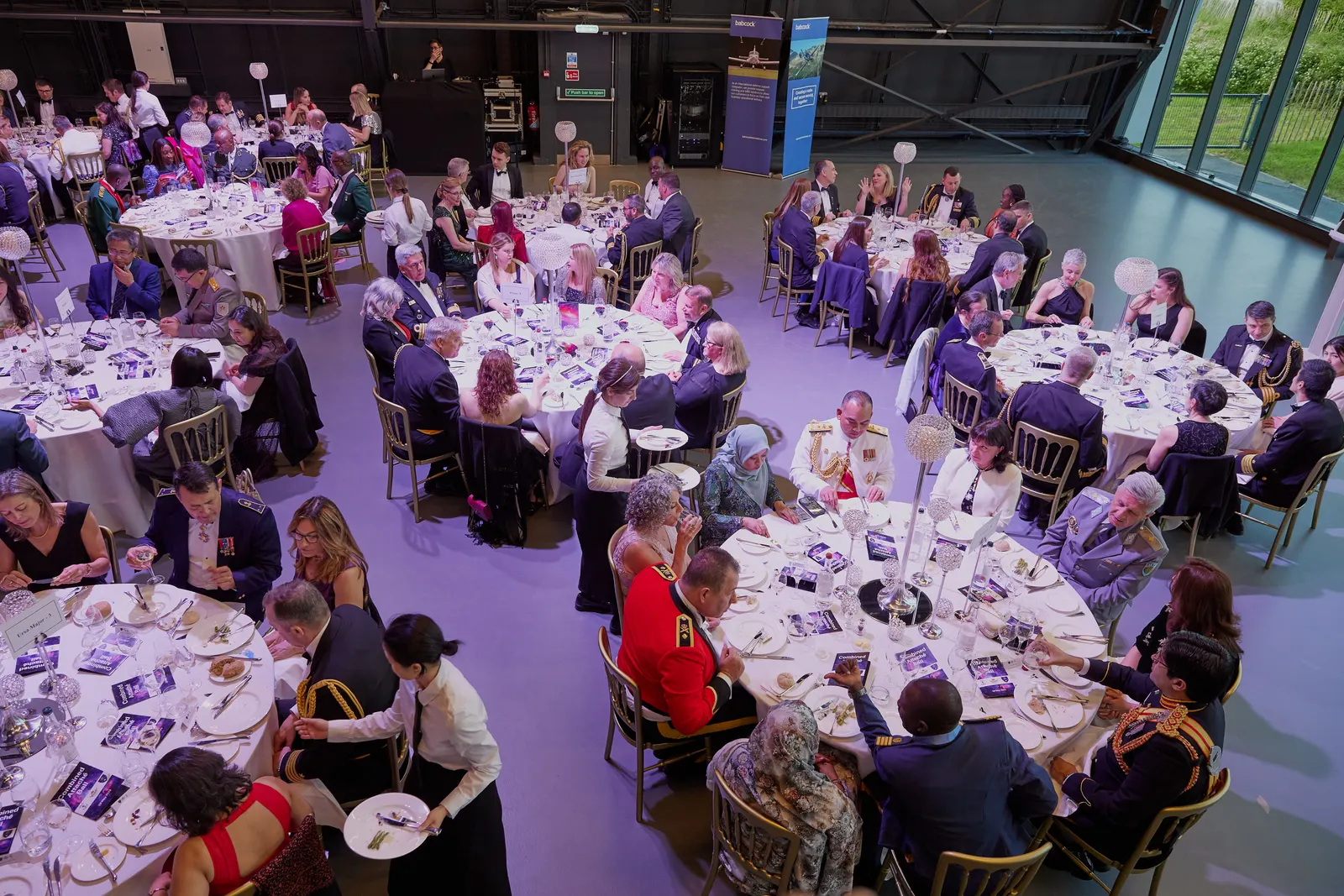 Overhead view of a formal gala dinner with round tables and guests in evening dress