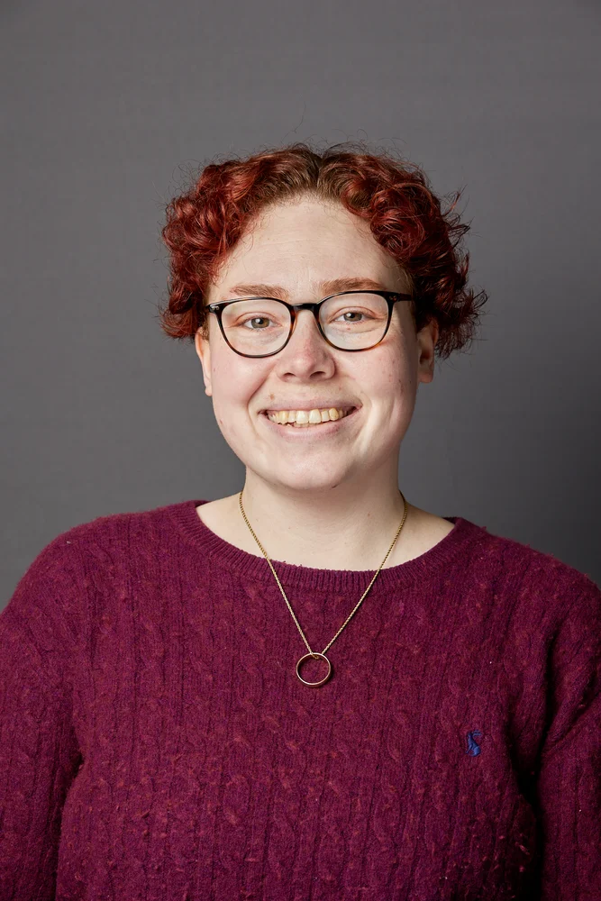 Professional corporate headshot on a grey backdrop