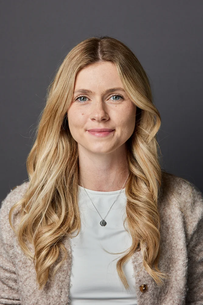 Professional corporate headshot on a grey backdrop