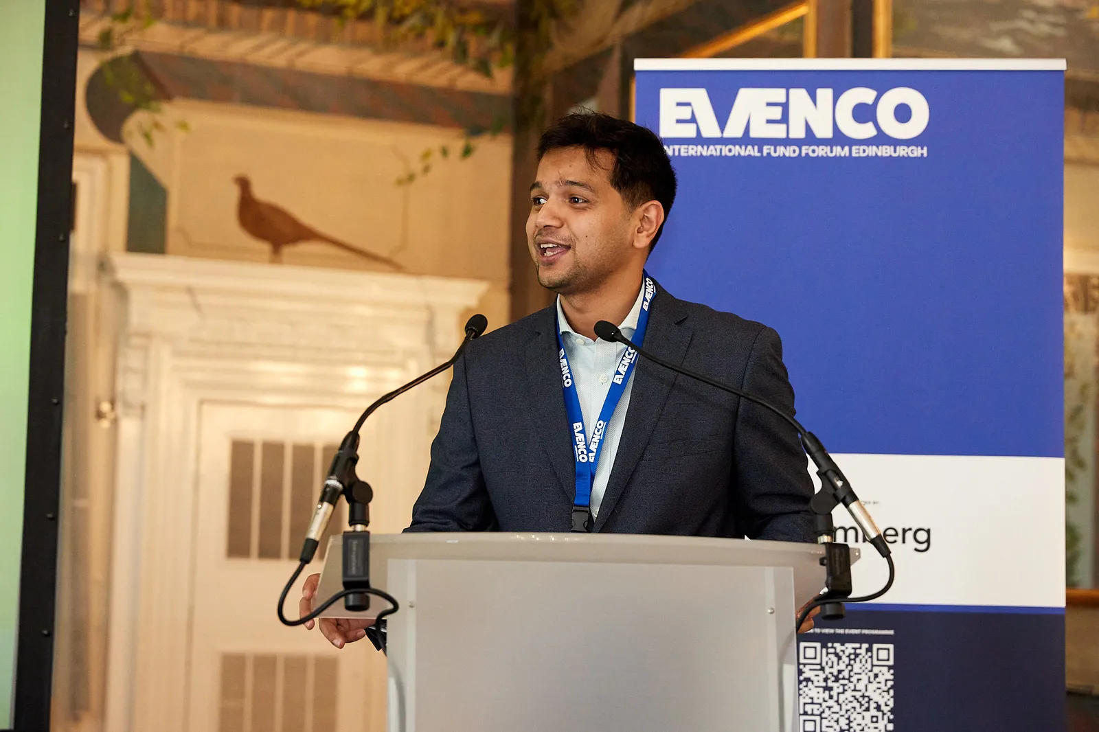 Keynote speaker presenting on a branded stage at a corporate conference