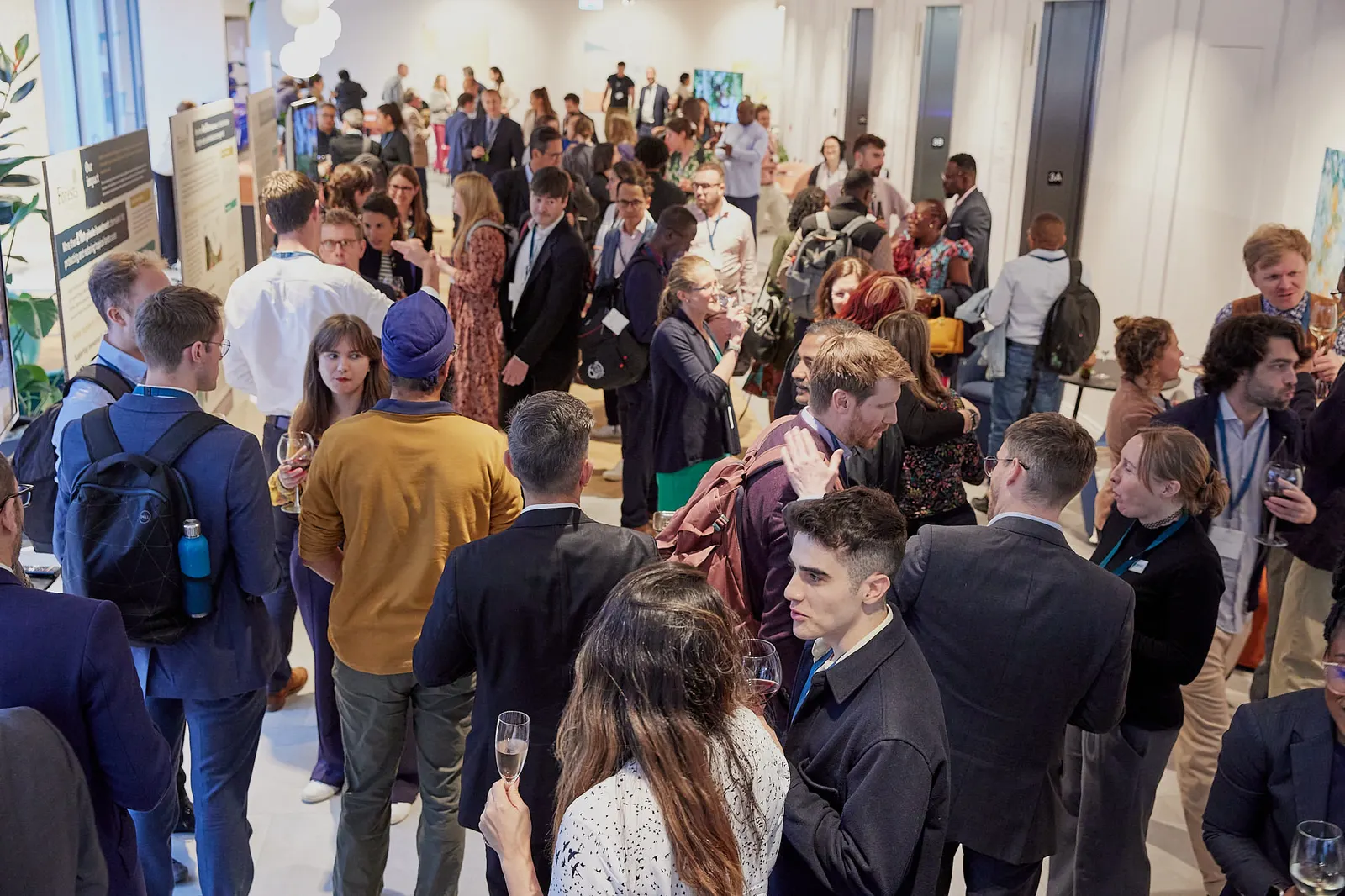 Wide view of a busy drinks reception at a business conference