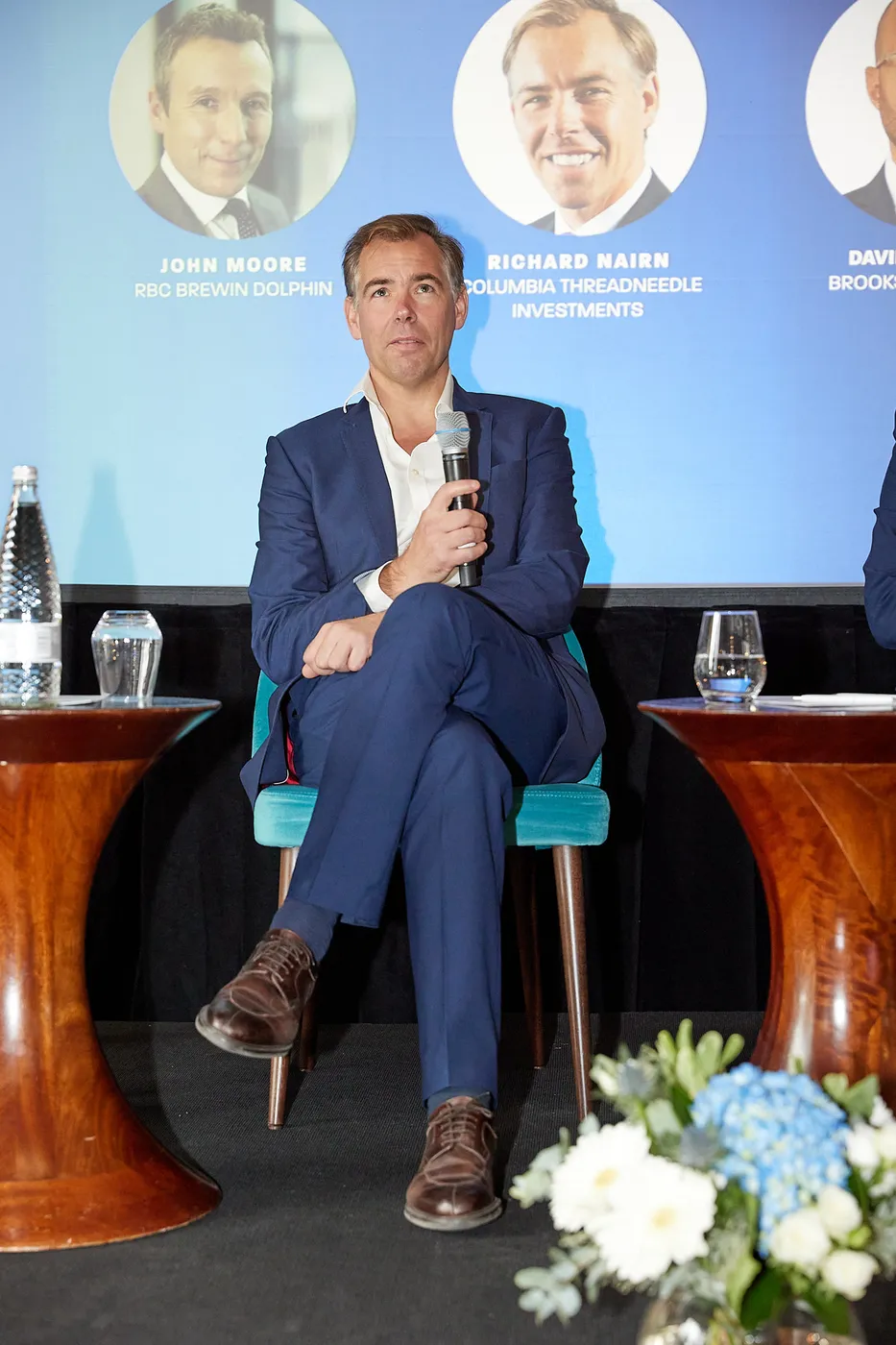 Speaker seated on stage at a corporate conference