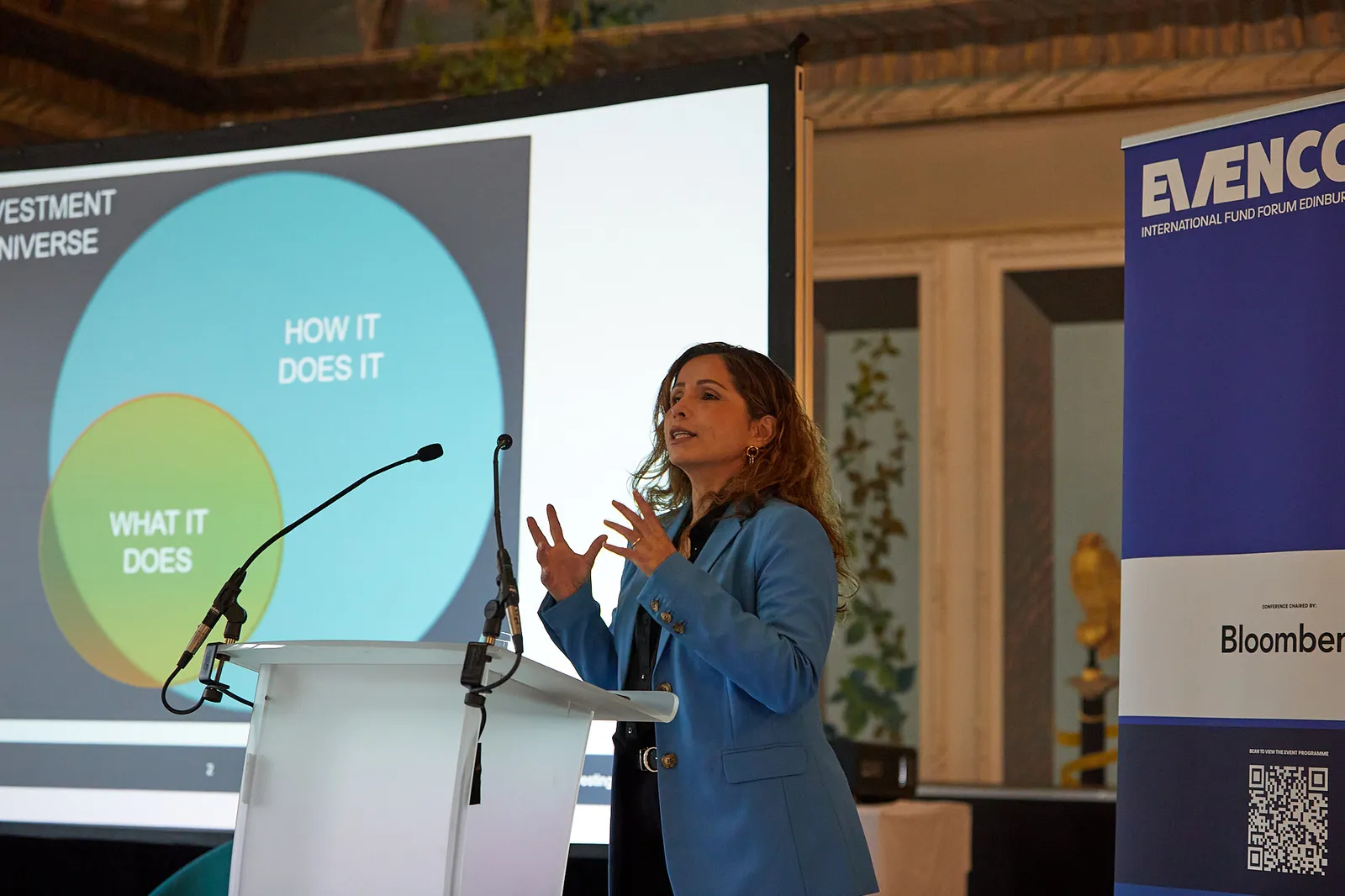 Speaker presenting to delegates with on-screen slides