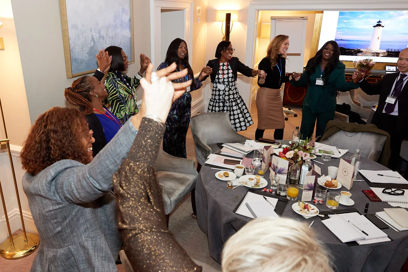 Attendees joining hands during a group activity at a leadership workshop