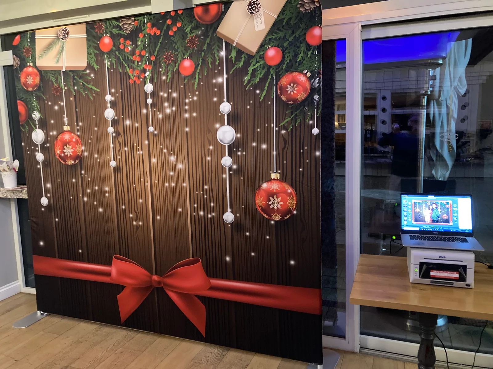Branded Christmas backdrop with instant print station at a party